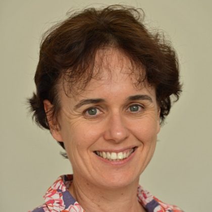Dr Lucy Gilkes smiles at the camera. She has short dark hair